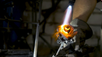 Blacksmith makes an iron rose. Man makes a rose out of iron