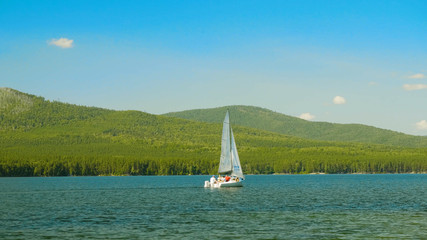 Fototapeta premium Sailboat on the water. Sailboats on the beautiful Lake of the. White sailboat floating on the lake