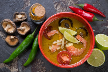 Above view of a bowl with thai green curry soup and its cooking ingredients