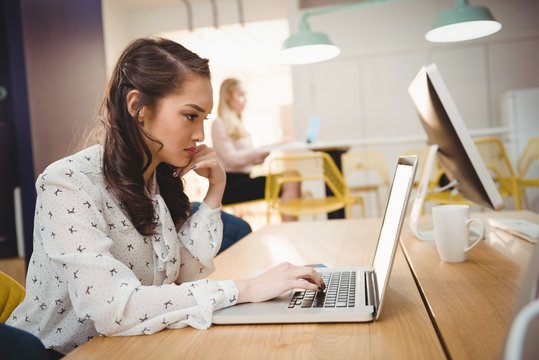 Female executive working on laptop in office