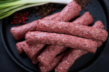 Close-up of fresh uncooked balkan cevapi or cevapcici sausages, selective focus, horizontal shot