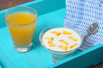 Yogurt with diced peaches and juice on the table.