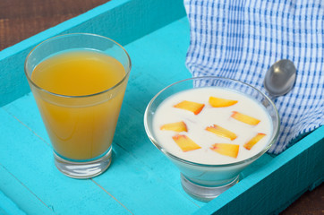 Yogurt with diced peaches and juice on the table.