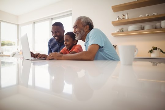 Multi-generation family using laptop in kitchen