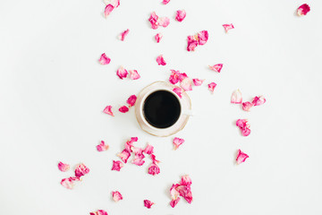 Cup of coffee and pink rose petals on white background. Flat lay, top view.