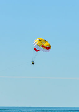 Colored parasail wing pulled by a boat in the sea water, Parasailing also known as parascending or parakiting