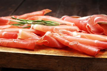 Italian prosciutto crudo or jamon with rosemary. Raw ham.