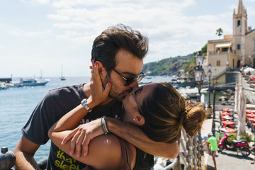 Kissing couple in sunny city