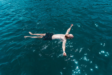 Man floating in blue water