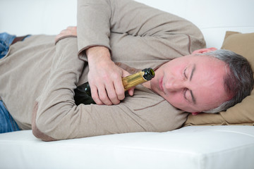 drunken man sleeps hugging a beer bottle