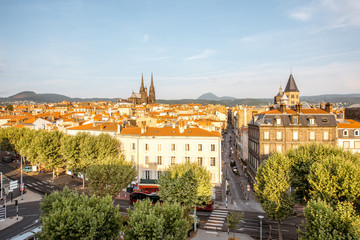 Fototapeta na wymiar Morning aerial cityscape view on Clermont-Ferrand city with beautiful cathedral and mountains on the background in central France