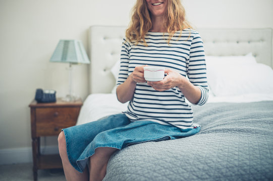 Happy woman in hotel room with cup