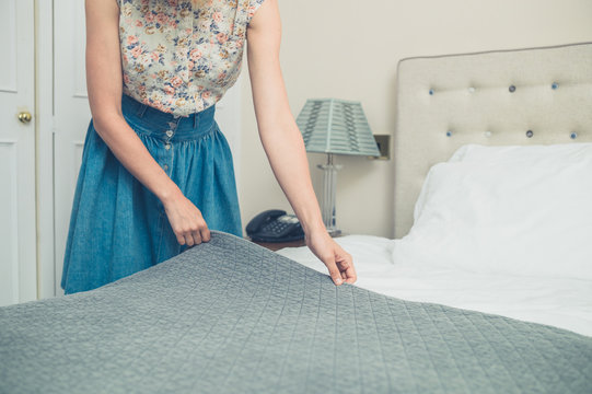 Young woman making the bed