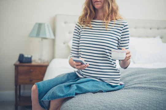 Woman with cup and smart phone in hotel room