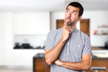 Handsome man having doubts inside house