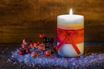 Christmas or Advent candle with snow and red berries decoration