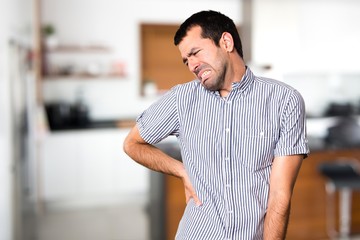 Handsome man with back pain inside house