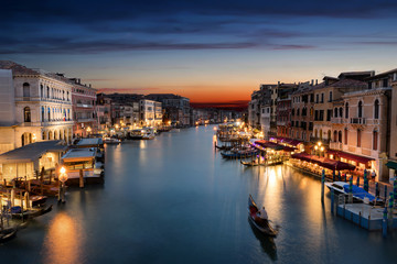 Fototapeta na wymiar Der Canale Grande in Venedig nach Sonnenuntergang mit vorbeifahrender Gondel