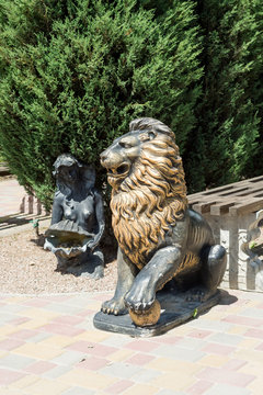 A bronze statue of an aggressive lion adorns the avenue in the park.