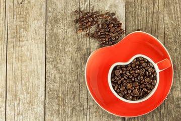 Coffee beans in a cup. Spilled coffee on a wooden table. Sales of fresh coffee.