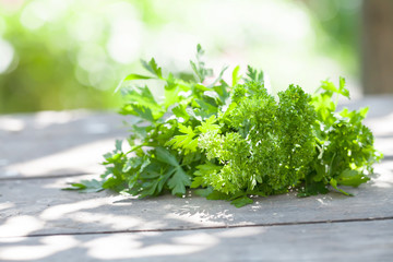 Parsley on wooden table. Farmers summer harvest still life. Selective focus, beautiful bokeh.