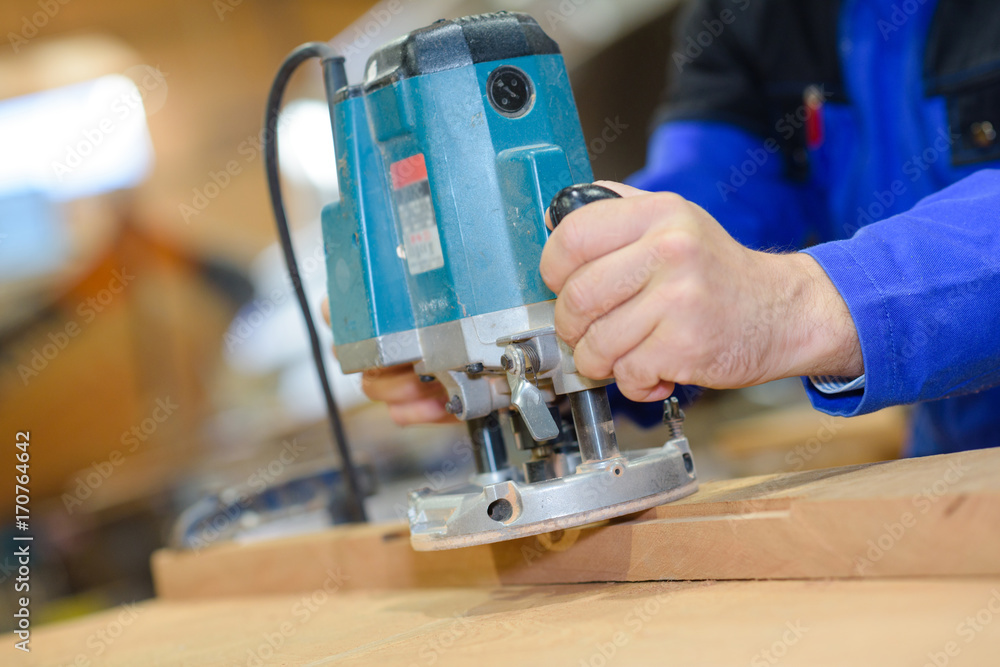 Wall mural electric sander carpenter sanding a wood with sander