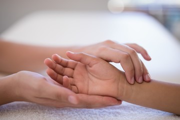 Close-up of female therapist examining wrist on white towel