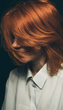 Portrait of ginger female whit hair covering face.