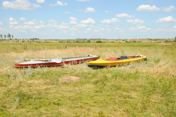 Fototapeta na wymiar Two kayaks standing on a green field