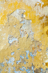 Background. Part of the old wall with peeling plaster. It was painted yellow
