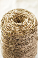 Close up coarse thread coil.  Twine thread on light blurred background