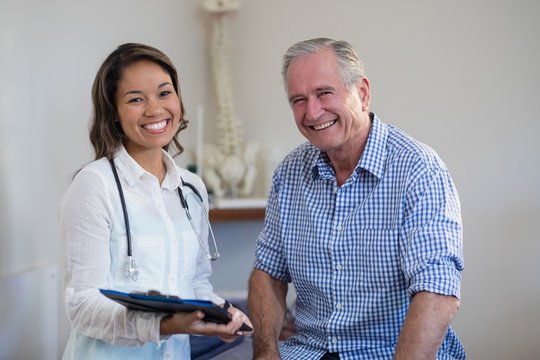 Portrait of smiling senior male patient and female therapist