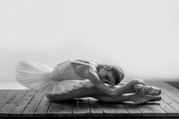 Calm ballerina posing on a wooden floor