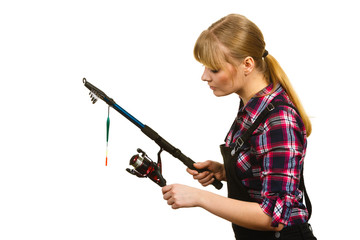 Woman in shirt looking at fishing rod