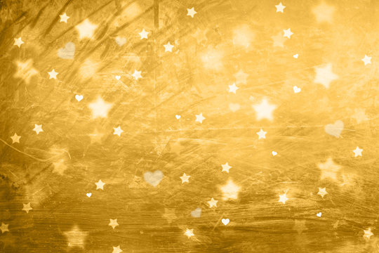 Textured blurry star and heart shapes, abstract Christmas and New Year Holidays copy space on shiny golden background.