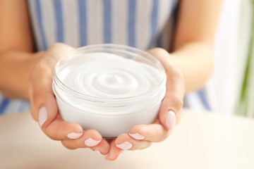 Woman holding jar with cocoa butter lotion