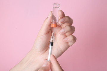 Doctor with syringe and medicine on color background, closeup