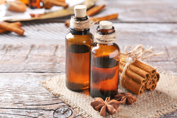 Beautiful composition with essential cinnamon oil in glass bottles on wooden table