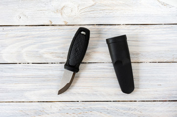 Swedish knife and plastic sheath in the center of the composition on white background.