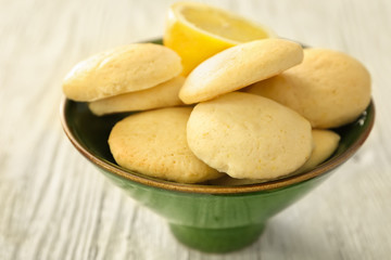 Bowl with homemade lemon cookies on wooden table
