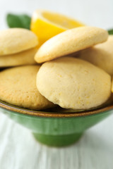 Bowl with homemade lemon cookies on wooden table