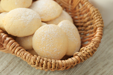 Wicker basket with homemade lemon cookies on table