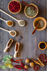 Colorful dry herbs and spices for cooking food wooden kitchen table background top view