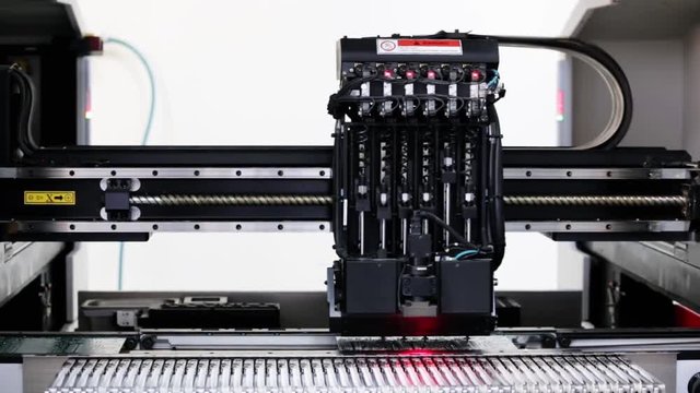 Automated Electronic circuit board production close up. Machine Produces Printed digital board, contract manufacturing. Manufacture of electronic chips. Robotic arm. Red light. Full HD. Contrast +