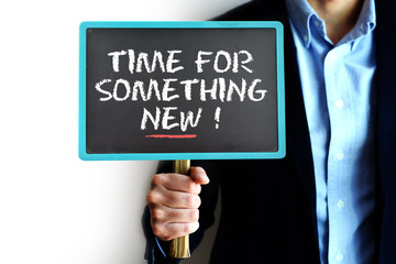 Time for something new with businessman holding small blackboard