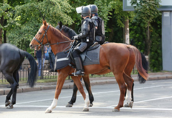 Mounted police patrolling street in town
