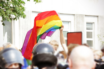 Concept of sexual minority. Man holding rainbow flag during gay parade outdoors