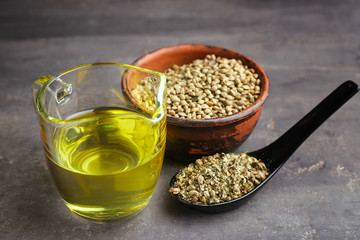 Composition with hemp oil and seeds on grey background