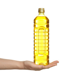 Female hand holding bottle of cooking oil on white background