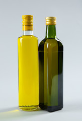 Bottles of cooking oil on light background